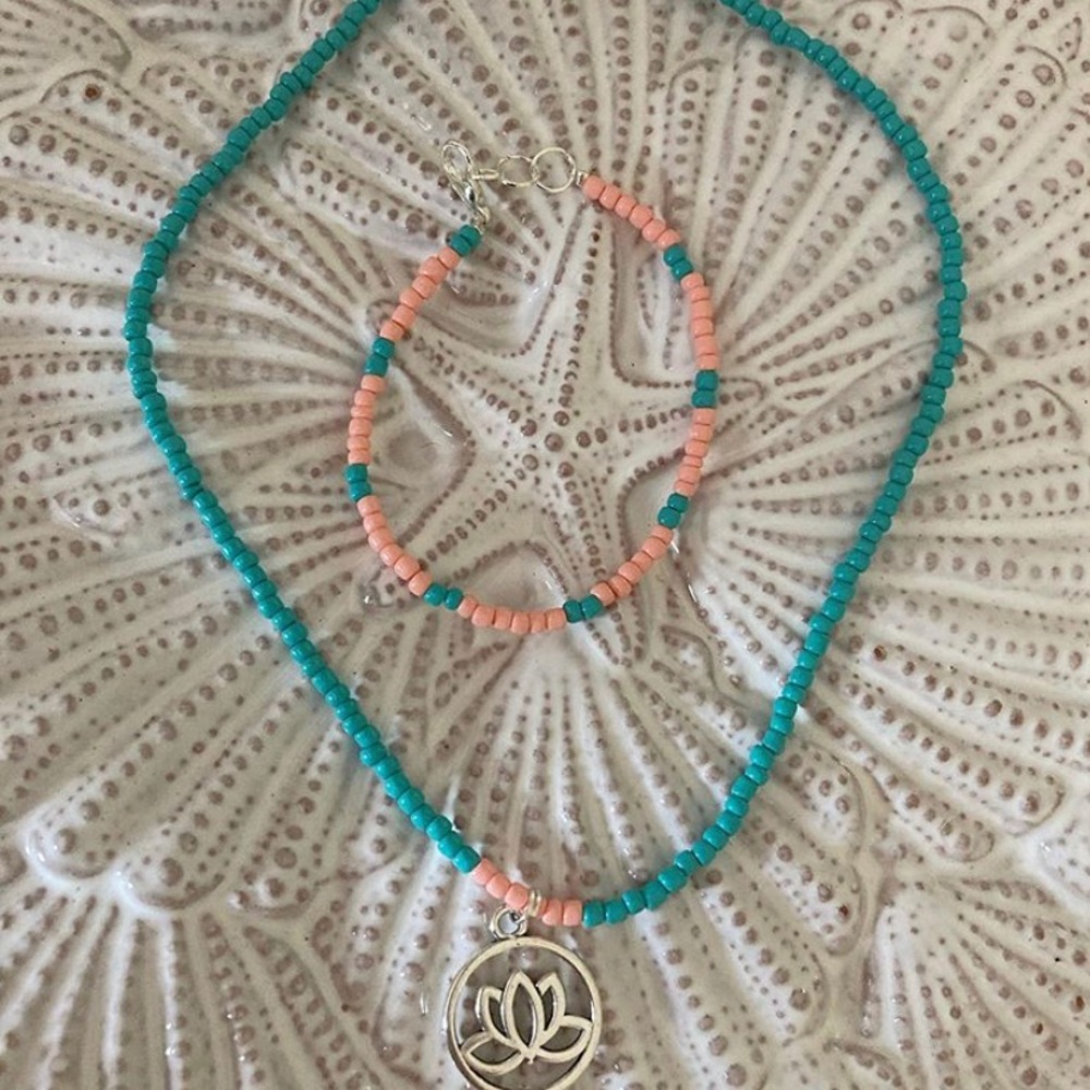 Beaded necklace with lotus charm and bracelet.